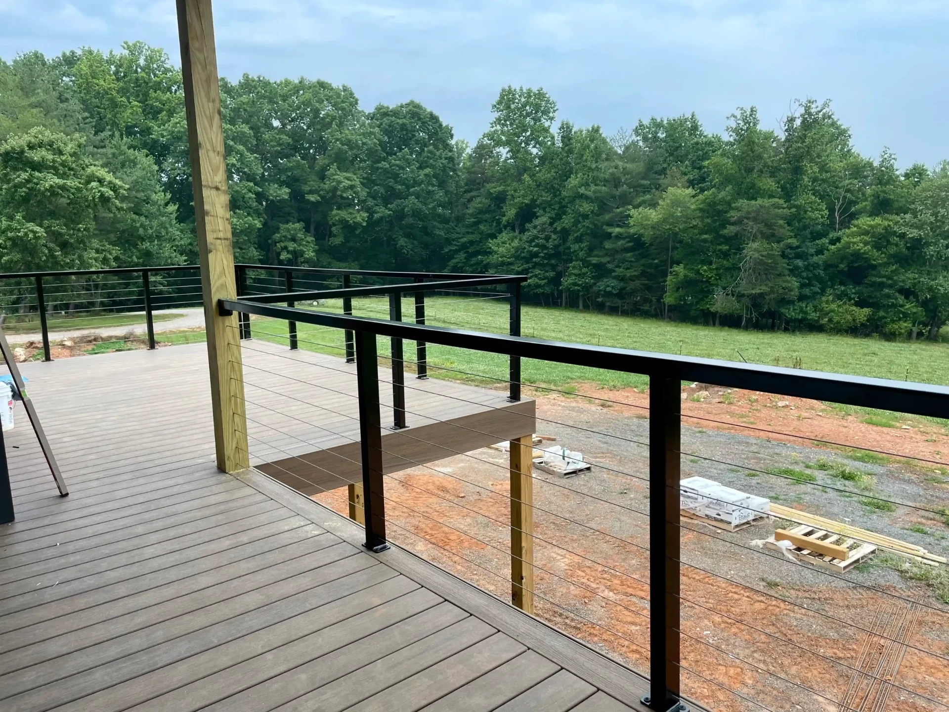 Expansive deck with black cable railing offering panoramic field views