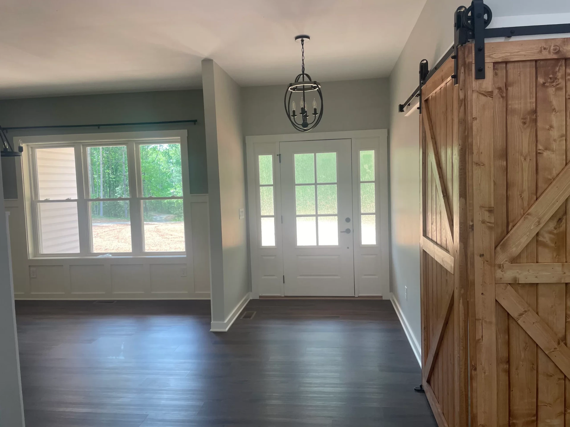 Entryway featuring sliding barn doors and pendant lighting