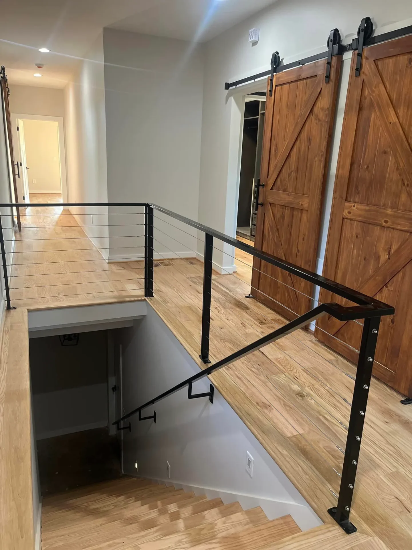 Modern staircase with barn doors and cable railing system