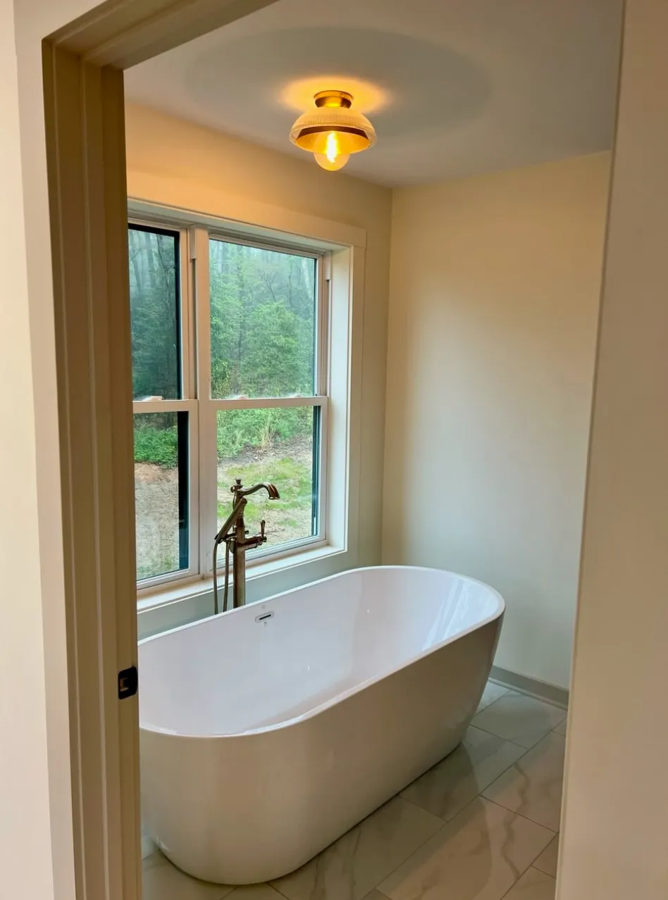 Modern bathroom with freestanding tub and large windows