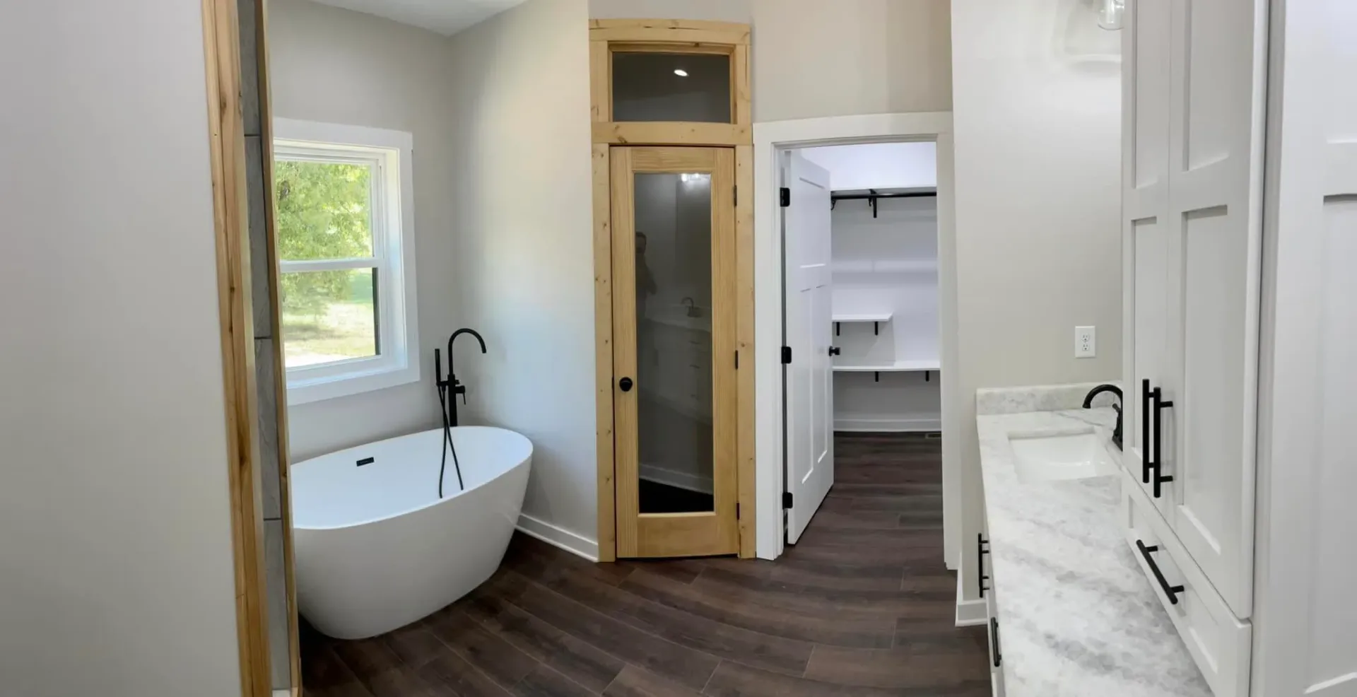 Master bathroom with wood-framed glass shower and freestanding tub
