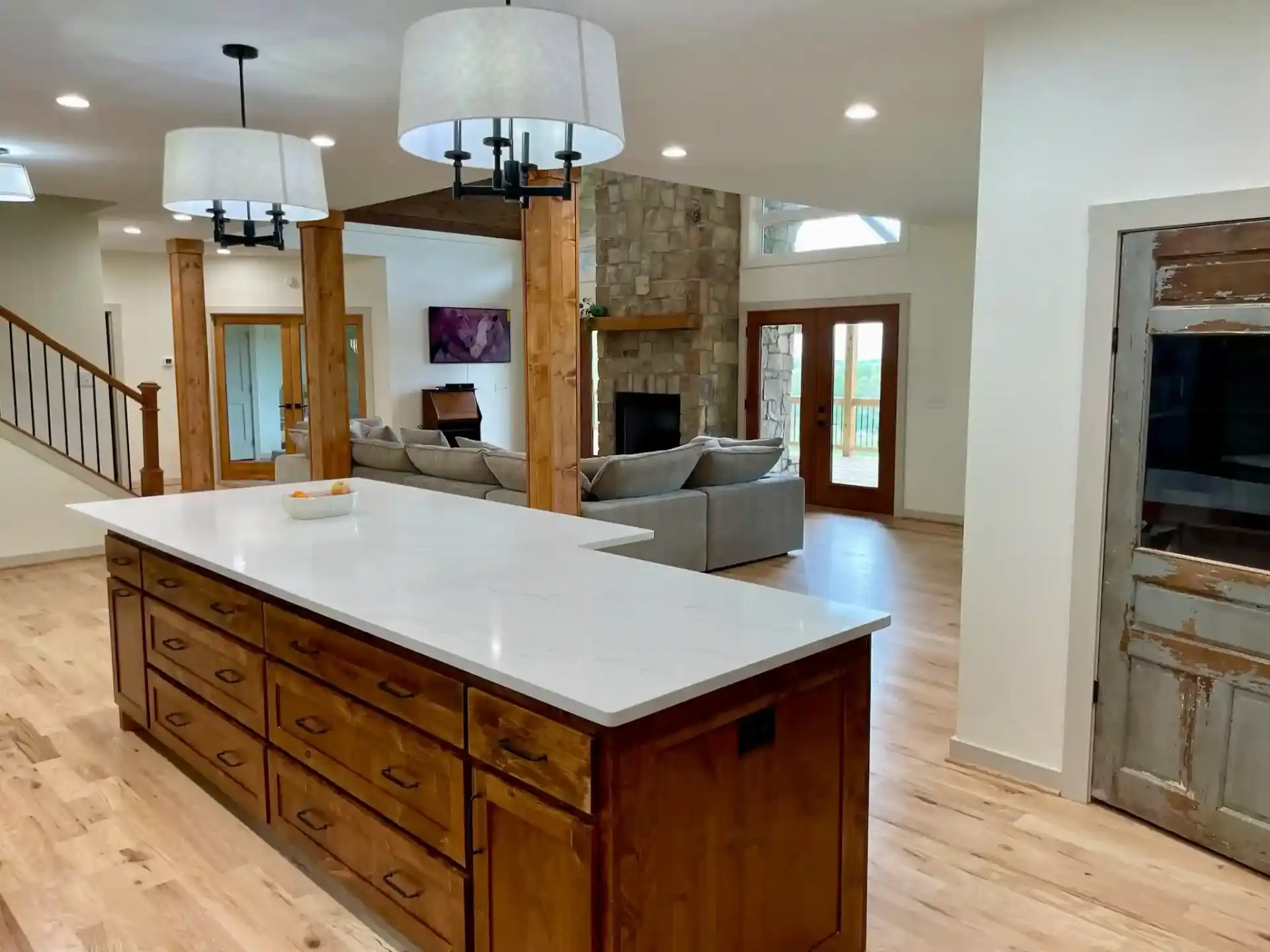 Spacious kitchen island with stone fireplace in background
