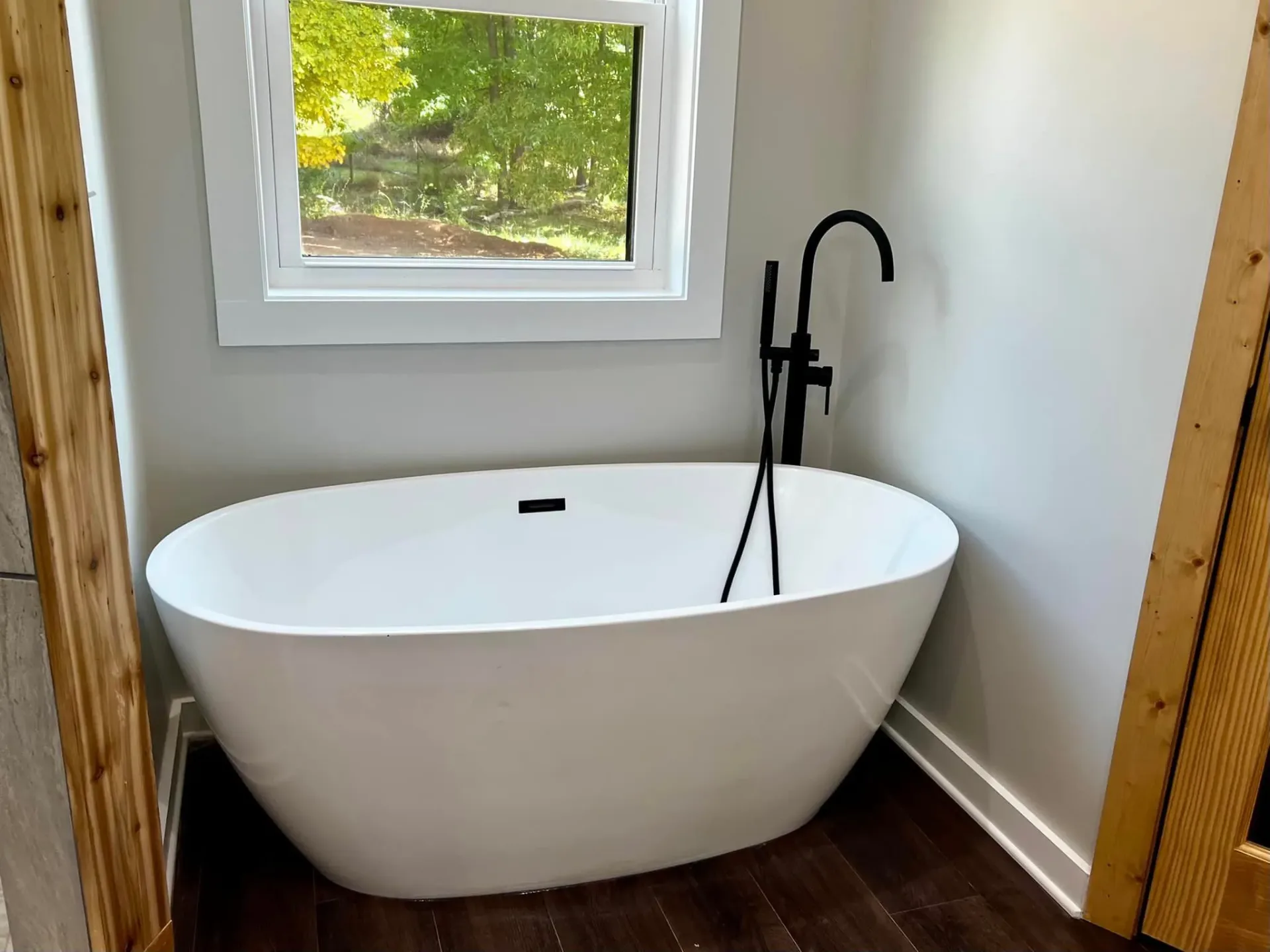 Modern bathroom with freestanding tub by window