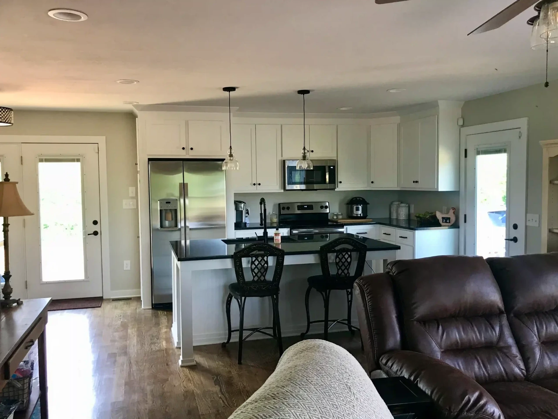Open concept kitchen with white cabinets and dark countertops