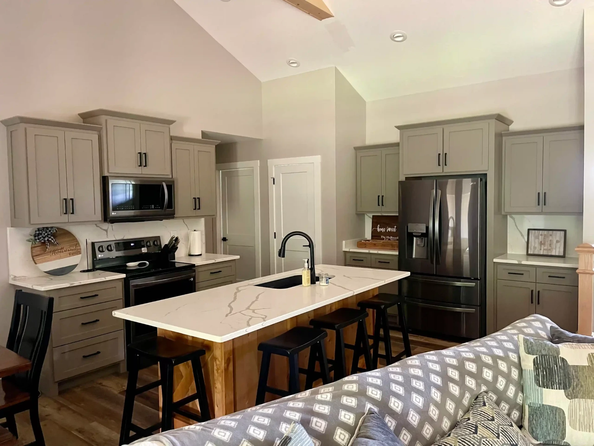 Open concept kitchen with gray cabinets and white quartz island