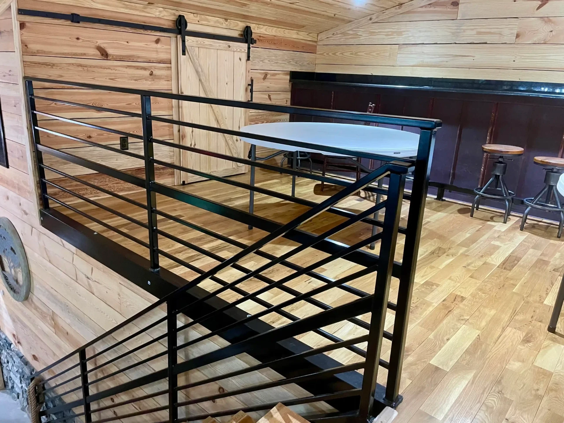 Rustic loft interior with black metal cable railing and wood accents