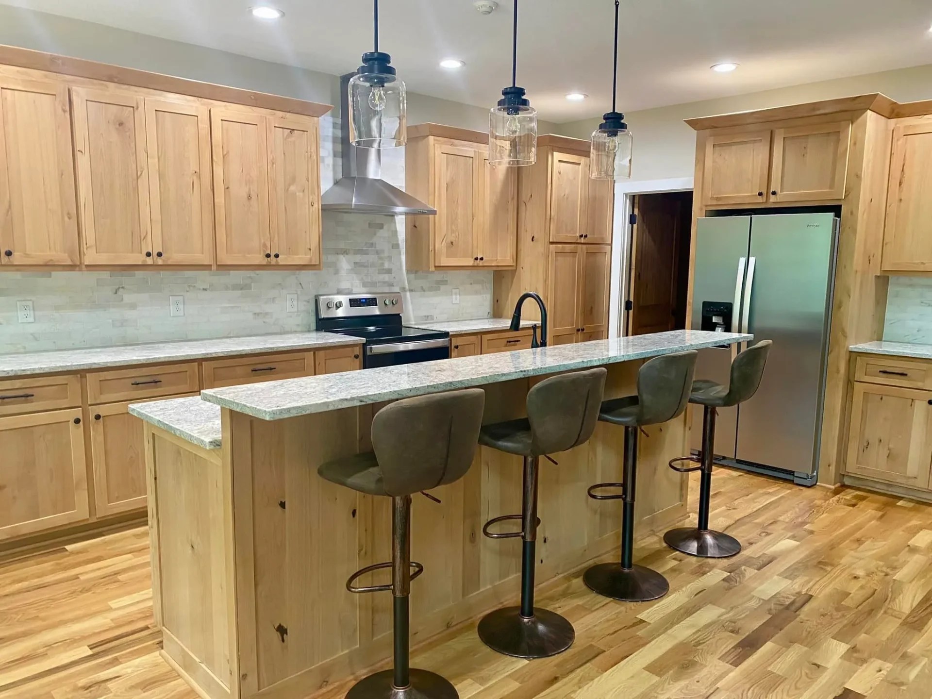 Natural wood kitchen with large island and pendant lighting