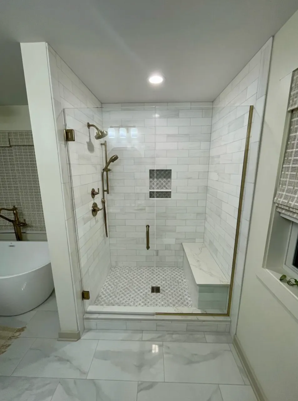 Modern bathroom with white subway tile shower and brass fixtures
