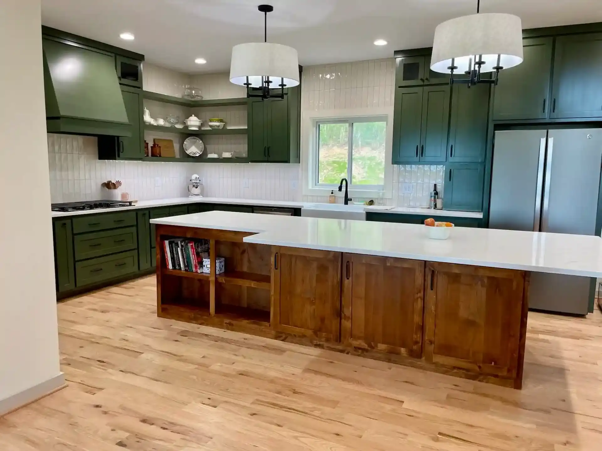 Modern kitchen with dark green cabinets and wood island with built-in storage
