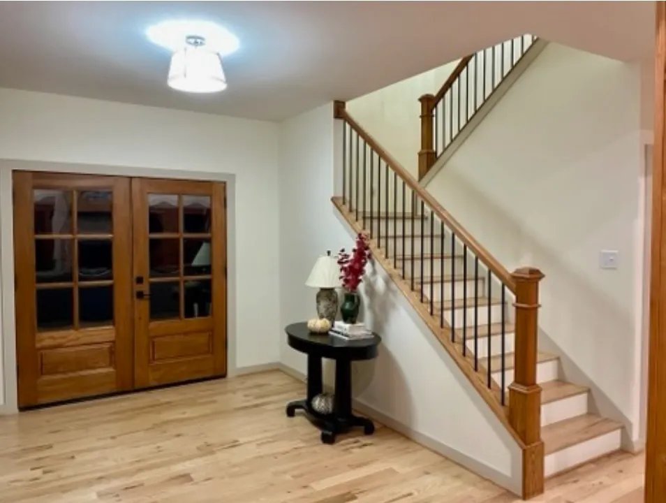 Traditional staircase in foyer with decorative table and lighting