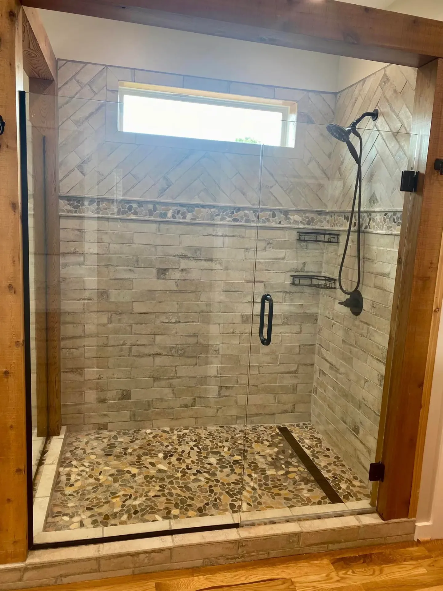 Walk-in shower with herringbone tile and river rock floor