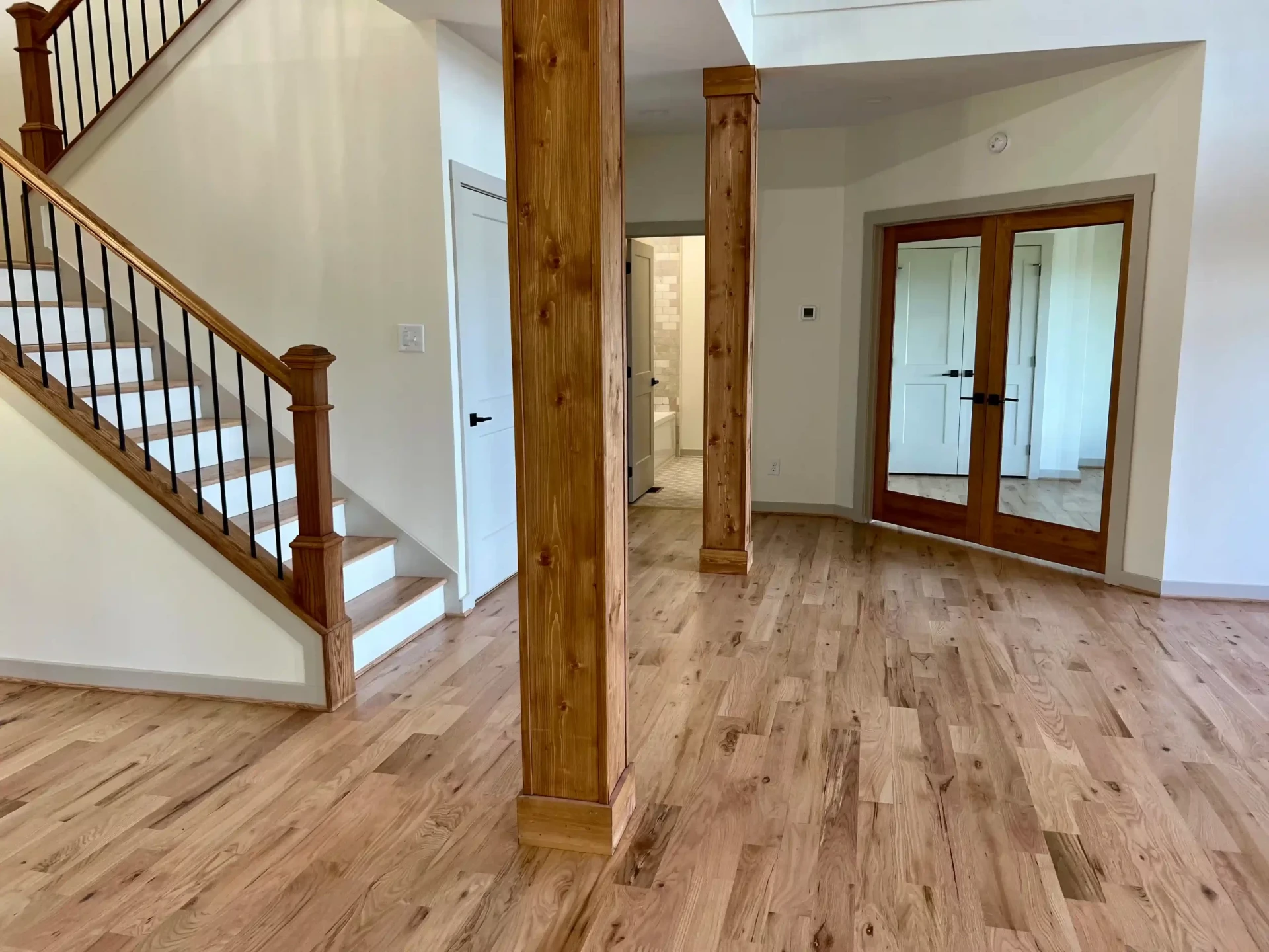 Elegant entryway with wood staircase and black iron spindles