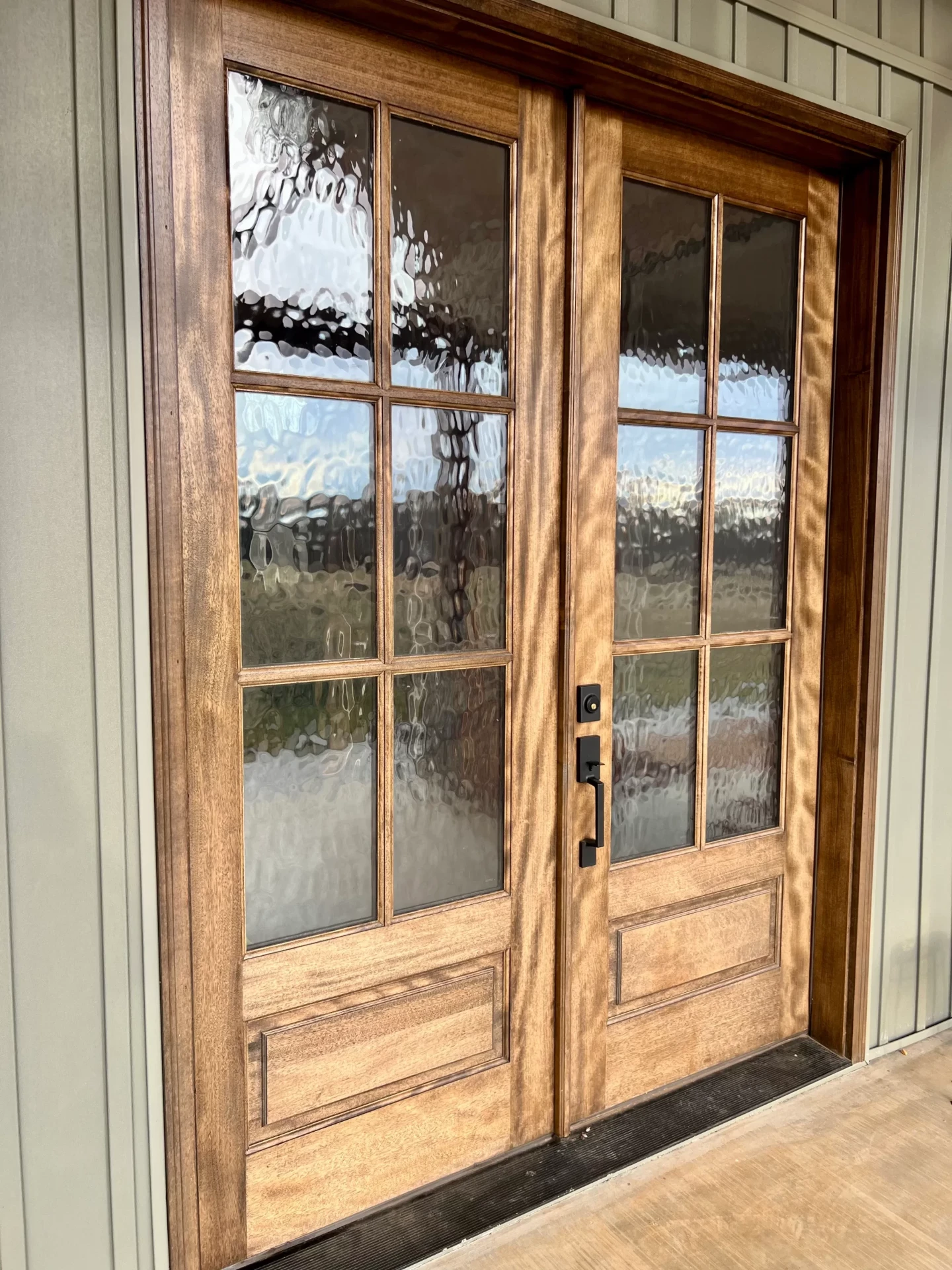 Double French doors with decorative glass panels and wood frames