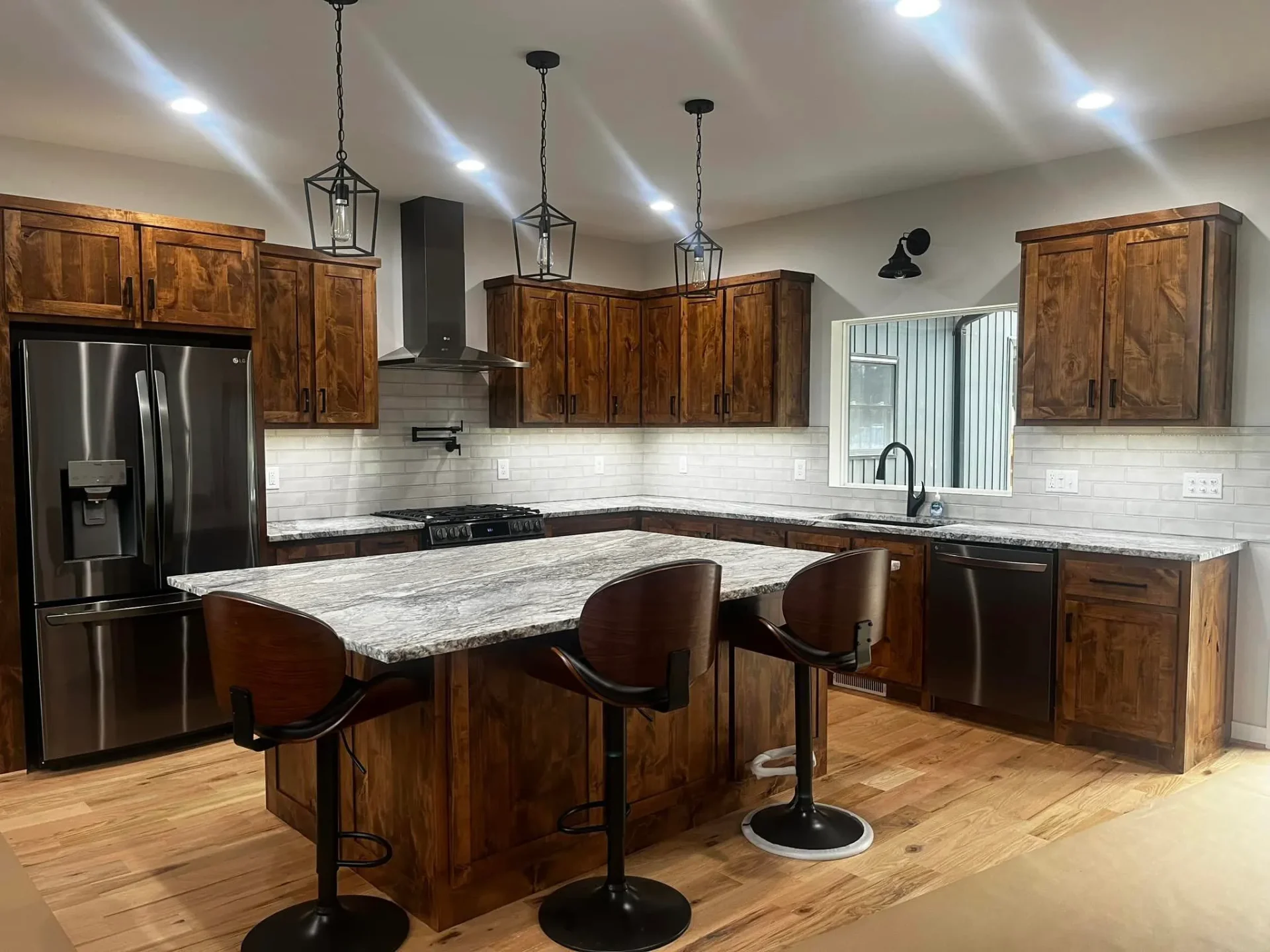 Rich wood kitchen with granite countertops and pendant lighting