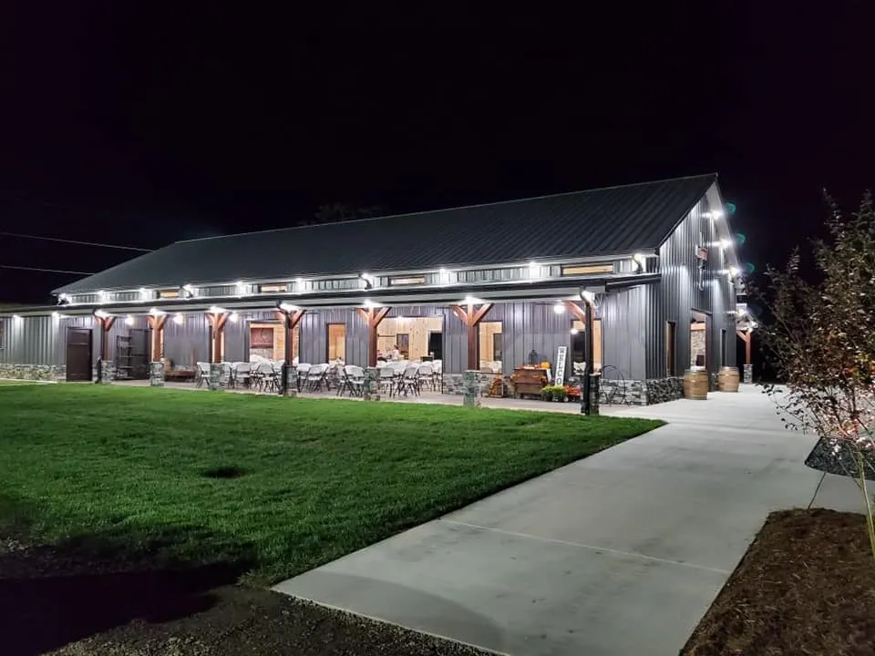 Nighttime exterior view of the barn with seating area