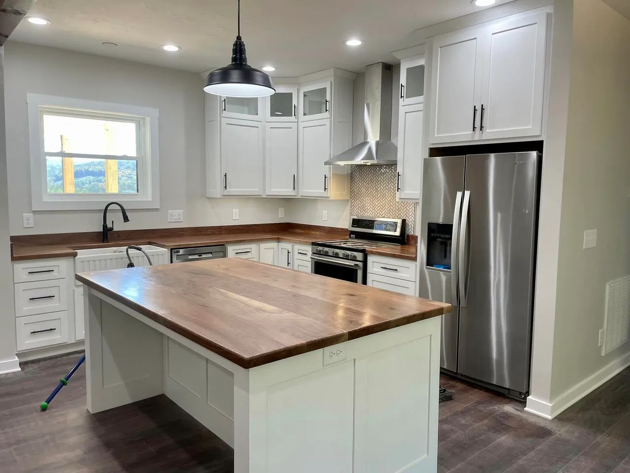Modern kitchen with white cabinets and wood countertops