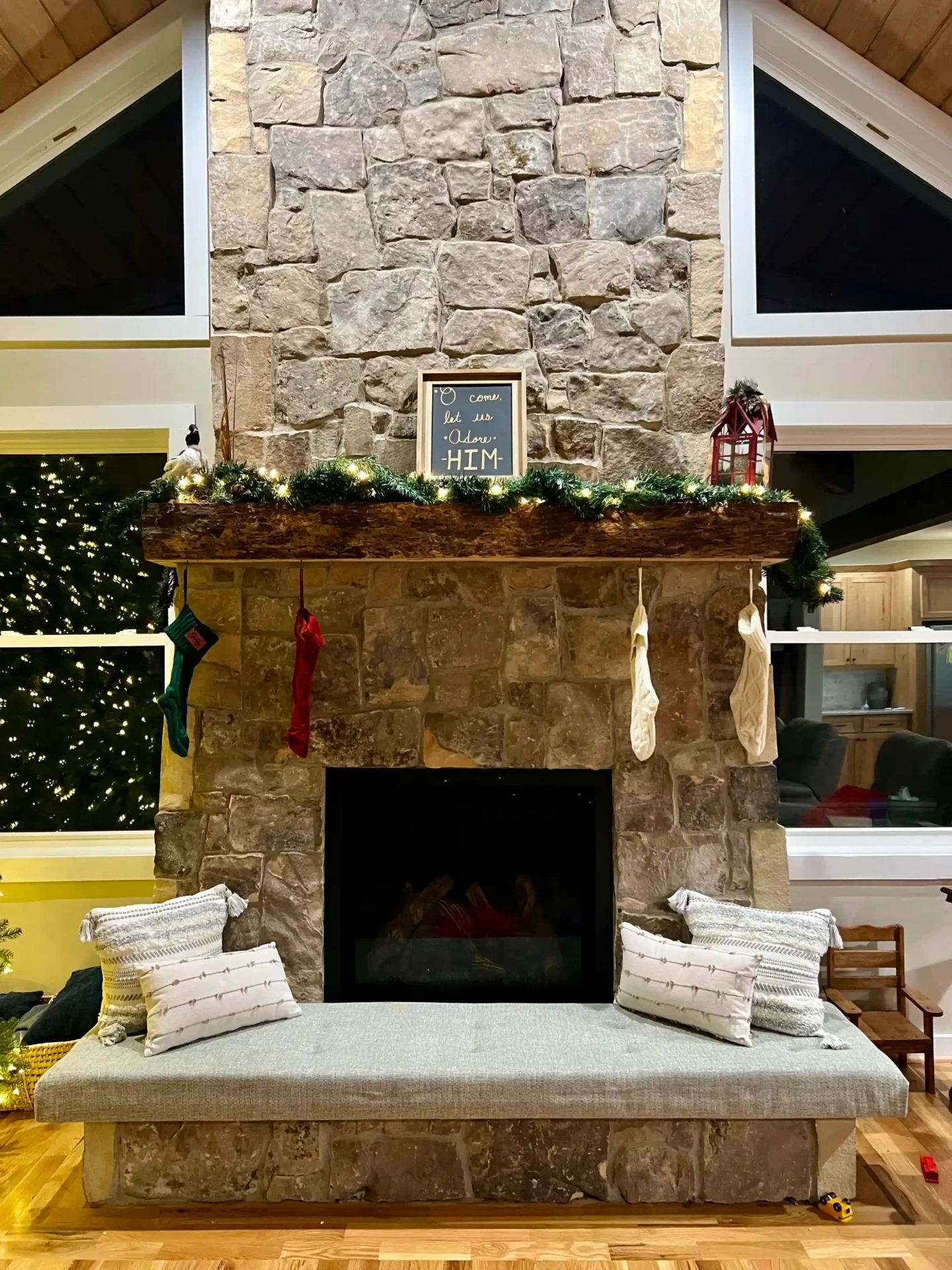 Traditional stone fireplace with Christmas decorations and hearth seating