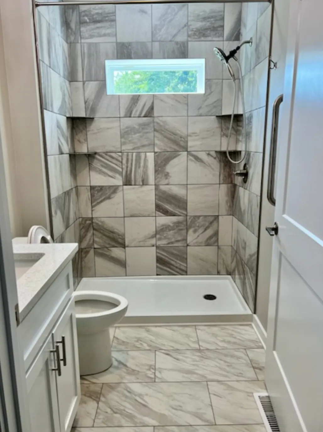 Contemporary bathroom with marble tile shower and window feature