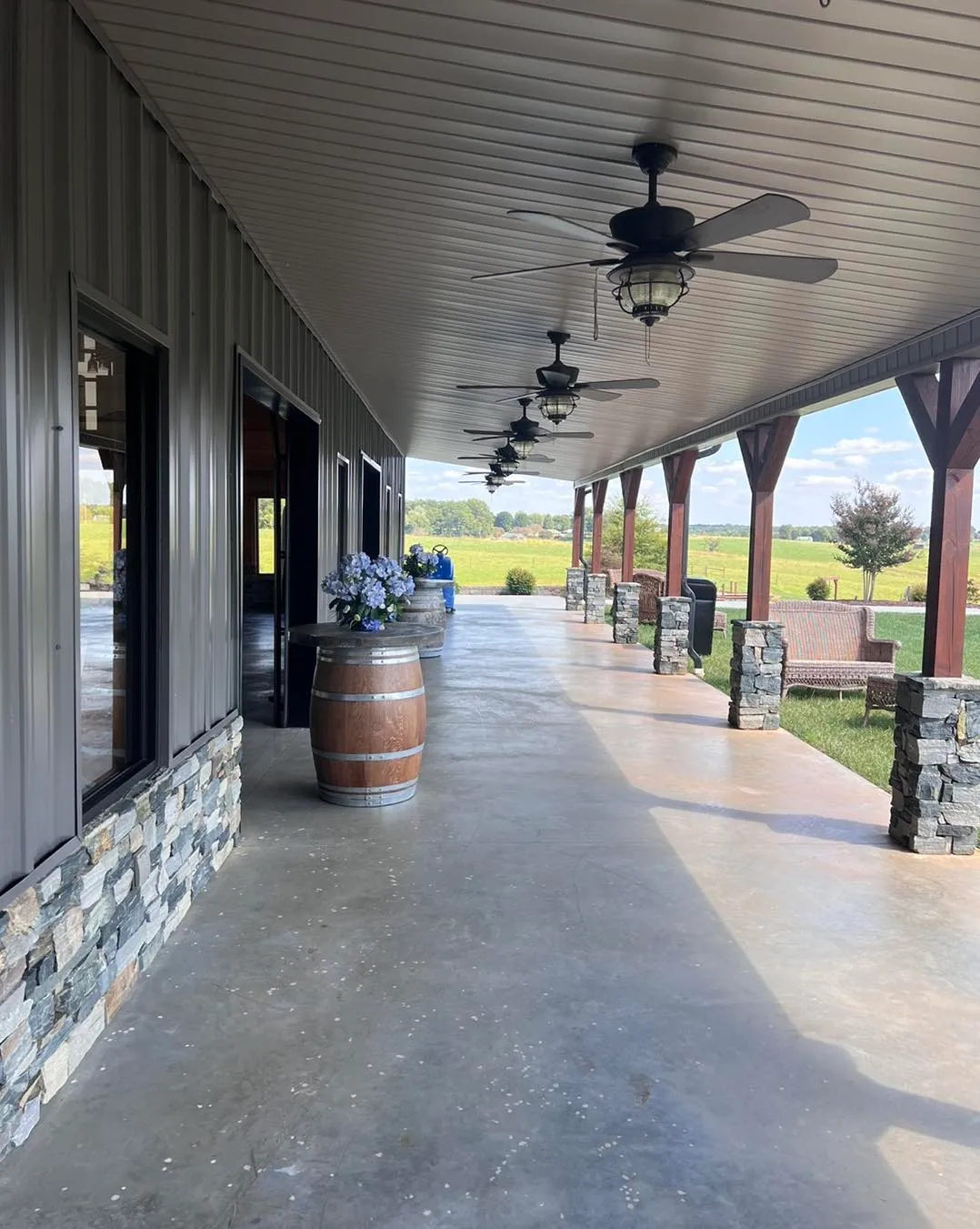Covered porch with ceiling fans and wine barrels