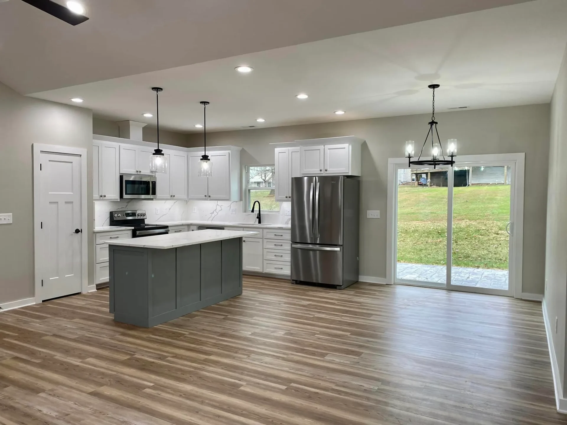 Contemporary kitchen with gray island and white cabinets