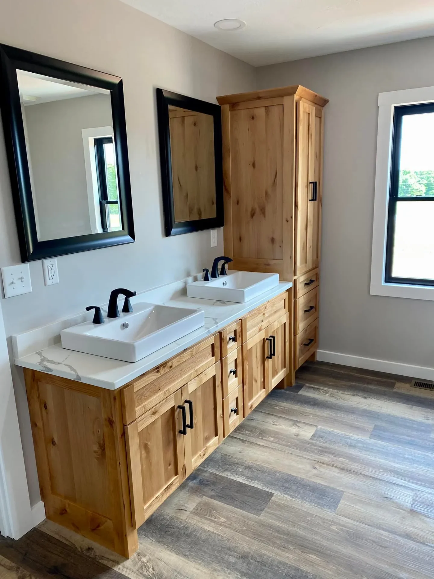Double vanity bathroom with rustic wood cabinets and white countertops