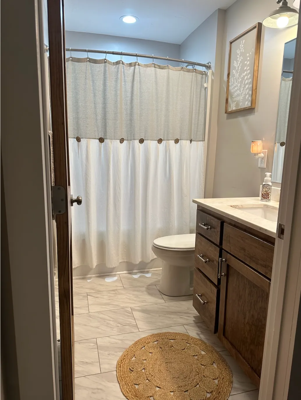 Bathroom with wood vanity and shower curtain